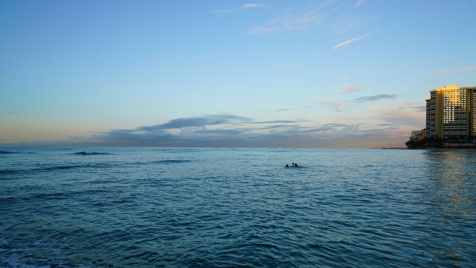 Looking over the water at sunset from Waikiki Beach.