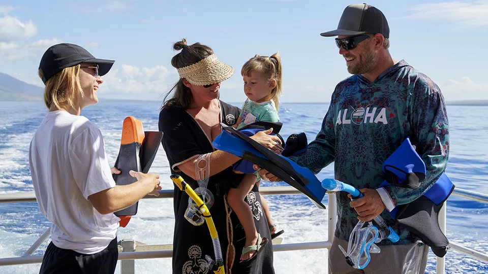 Crewmember Helping Family with Snorkel Gear on Molokini Tour