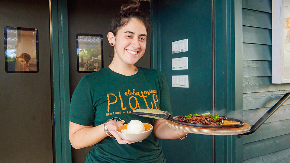 Server holding a plate of food from Aloha Mixed Plate in Lahaina