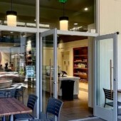 Island Vintage Coffee at The Shops at Wailea, with the logo on the window, open doors, and patio tables.