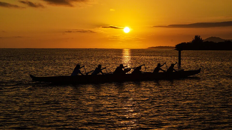 Ancient Hawaiian Voyagers Rowing Canoe at Sunset