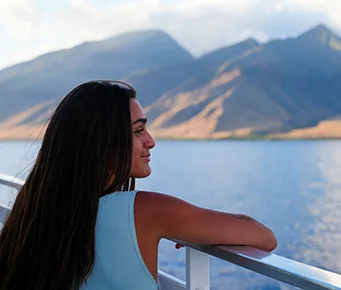 Guest relaxing on the deck of the Pride of Maui ʻElua, enjoying panoramic ocean views and island scenery.