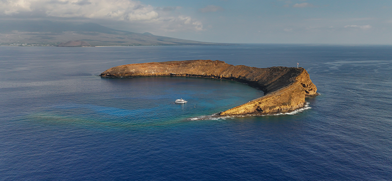 Aerial view of Molokini Crater with calm to lightly textured water in Maui