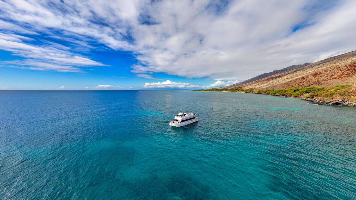 Maui snorkel boat near calm coastline reef chosen for favorable ocean conditions