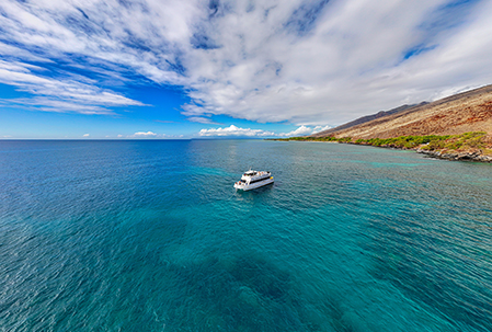 Maui snorkel boat near calm coastline reef chosen for favorable ocean conditions