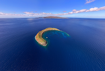 Aerial view of Molokini Crater off Maui with snorkel boats moored inside the crescent