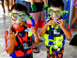Boys with snorkels posing for a photo on the Pride of Maui boat.