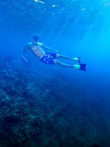 Snorkeler in clear blue water at Molokini